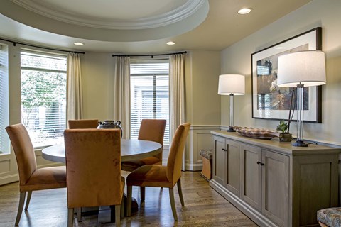 A dining room with a table and chairs.