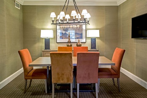 A dining room with a table and chairs.