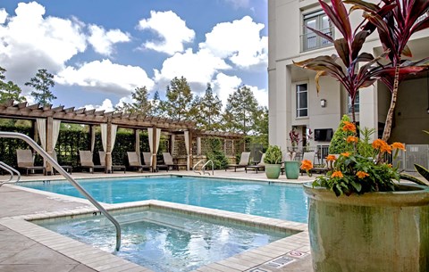 A pool with a slide and a building in the background.