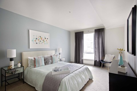 A bedroom with a large bed and a painting on the wall.