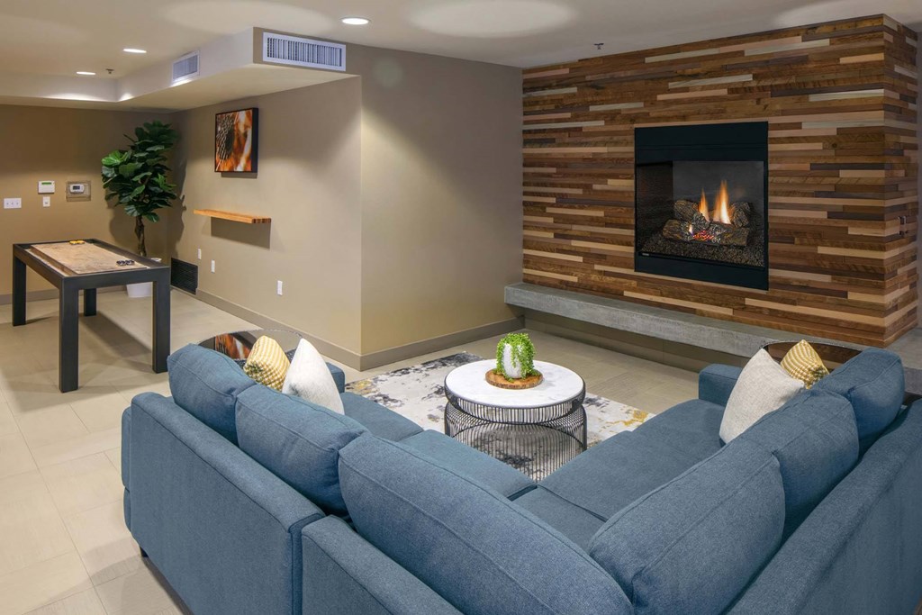 A living room with a blue couch and a fireplace.