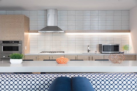 A modern kitchen with a stove top oven and a microwave above it.
