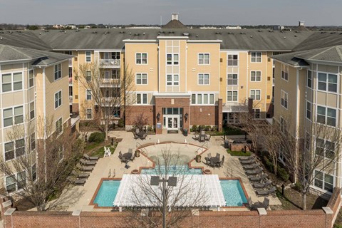 A large apartment complex with a pool in the middle.