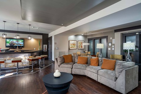 A modern living room with a grey couch and a black coffee table.
