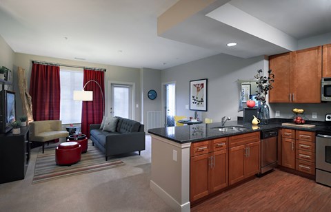 A modern kitchen with dark wood cabinets and a black countertop.