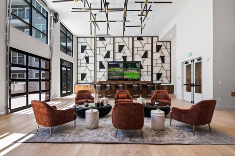 A modern living room with a large screen tv and comfortable seating.