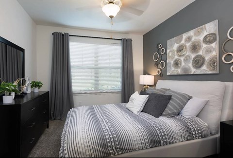A bedroom with a large bed and a chandelier.