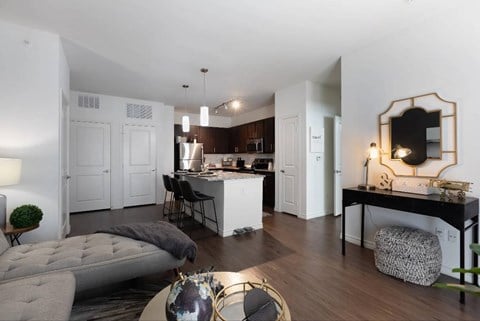 A modern living room with a grey sofa and a wooden floor.
