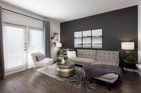 A modern living room with a grey sofa, a white chair, and a coffee table.