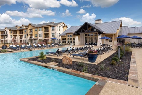A large swimming pool with a building in the background.