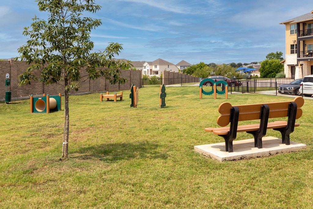 A park with a bench, a tree, and a playground.