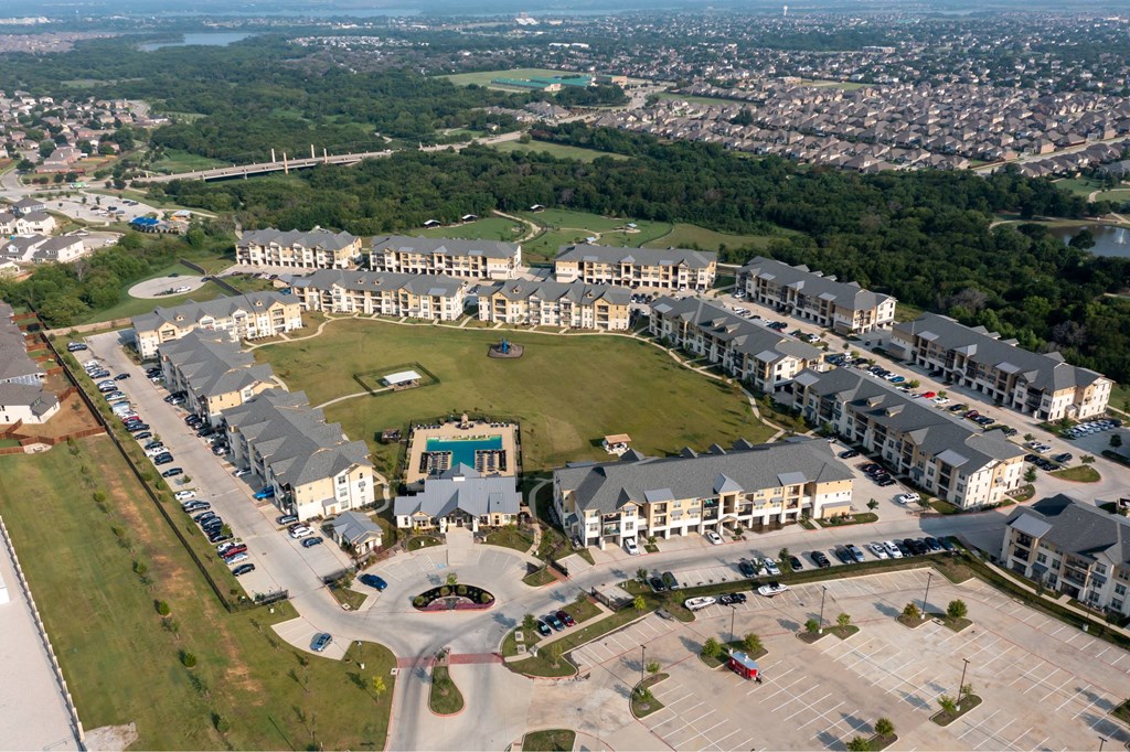 A large, modern building complex with a parking lot in front.