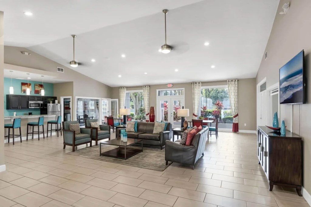 A spacious living room with a kitchen area in the background.