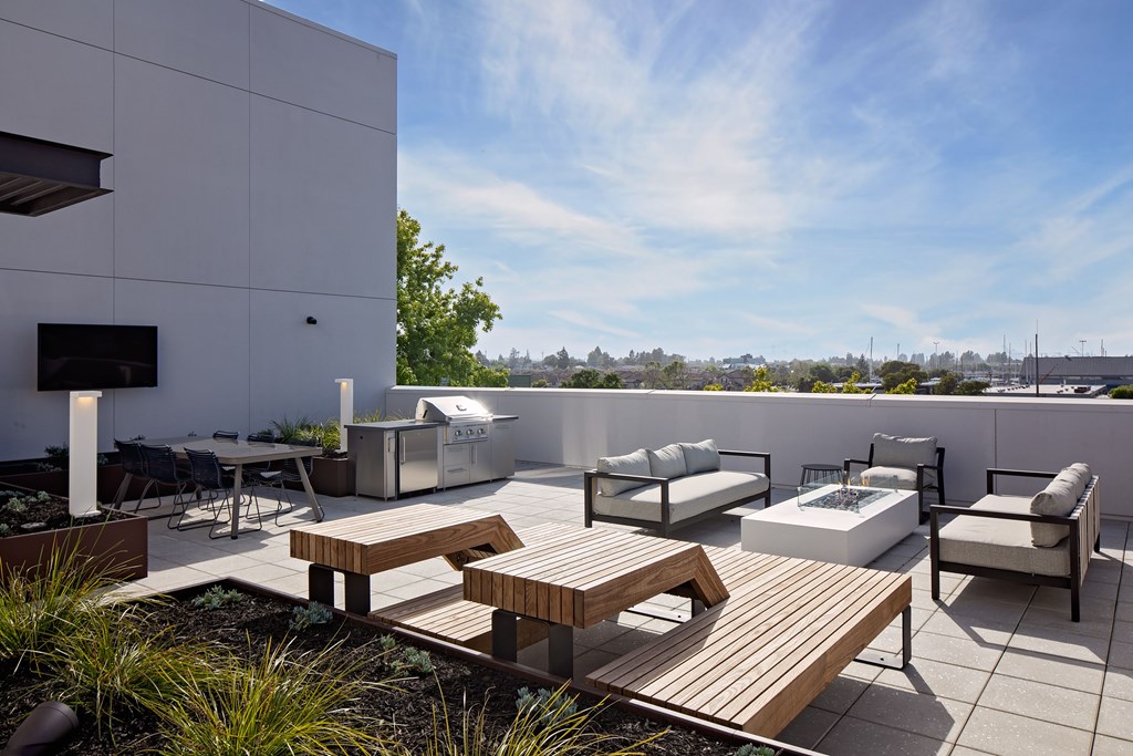 A modern outdoor patio with a wooden table and chairs.
