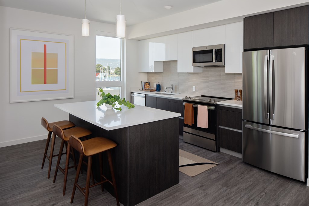 A modern kitchen with a large island and stainless steel appliances.