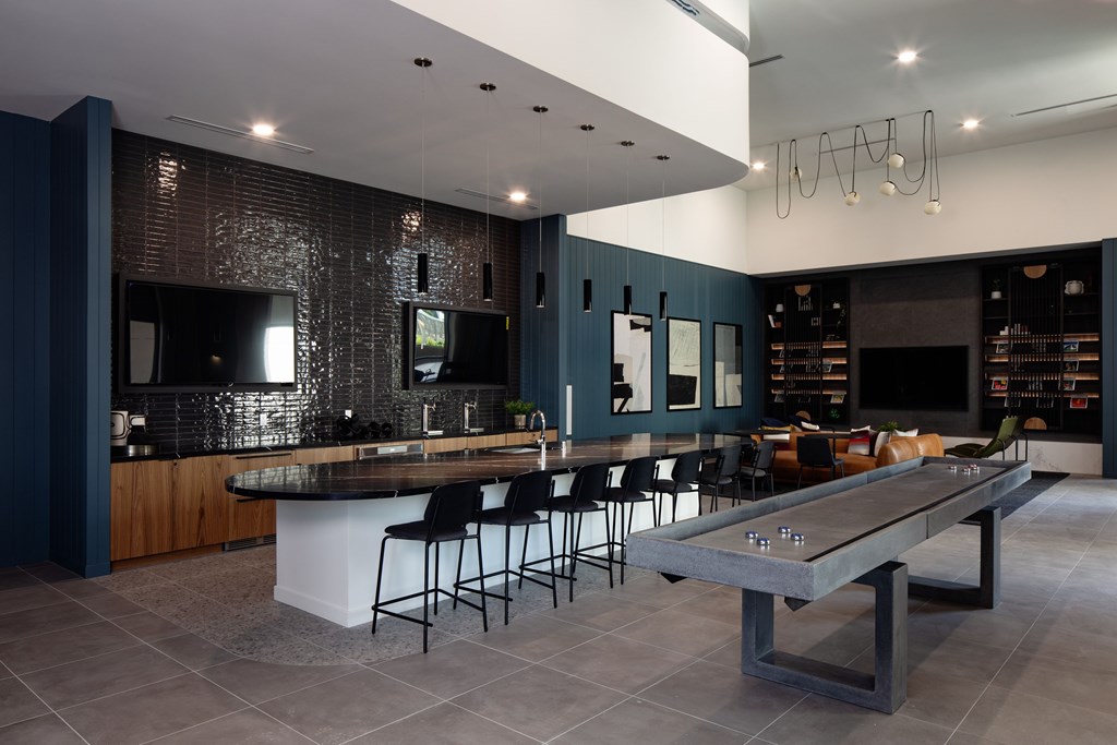 A modern kitchen with a long island and bar stools.