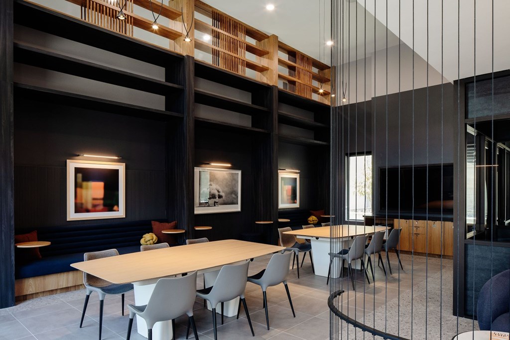 A modern dining room with a long table and chairs.