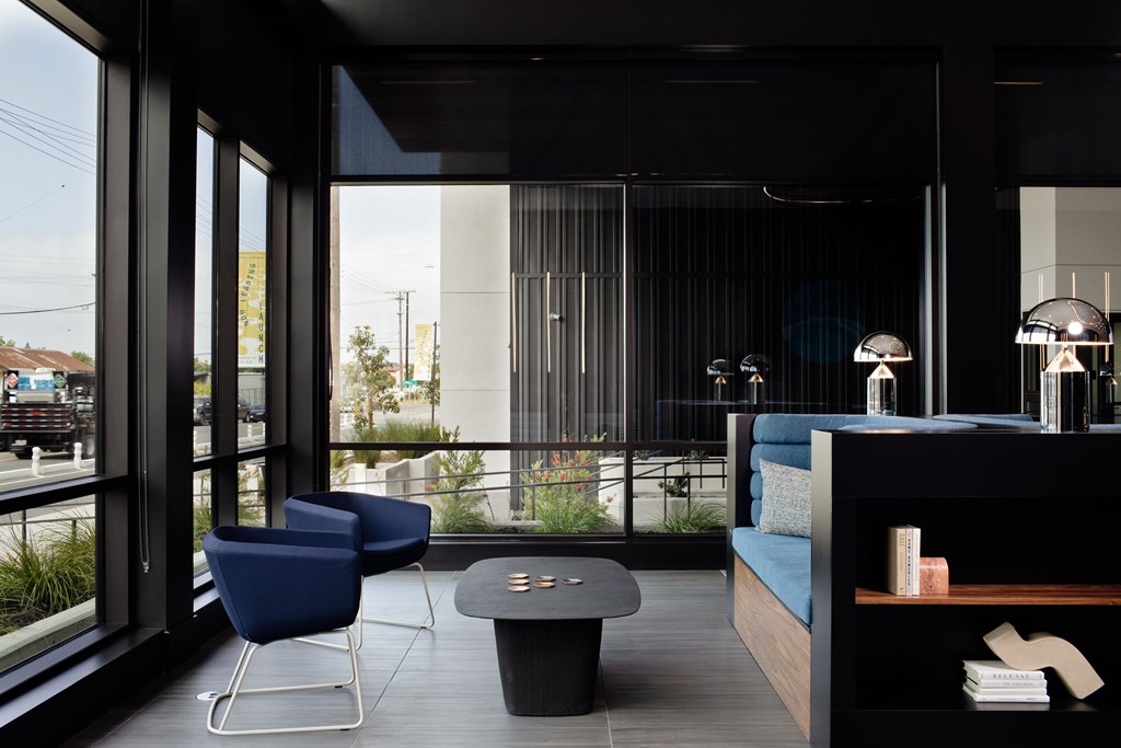 A modern living room with a blue chair and a black table.