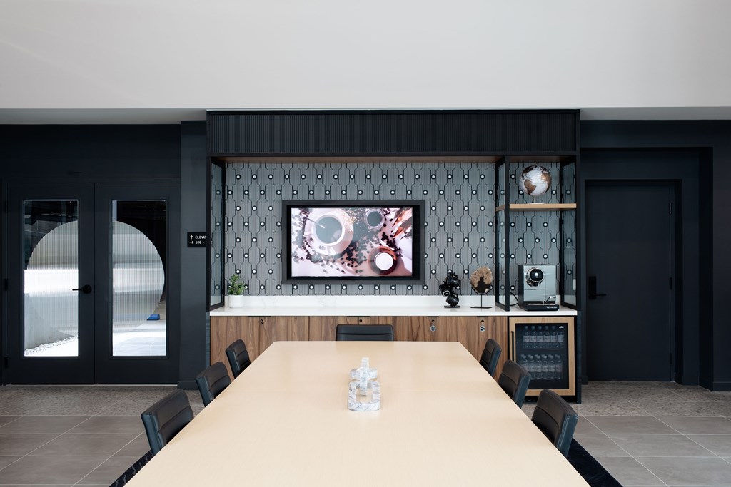 A conference room with a long table and chairs.
