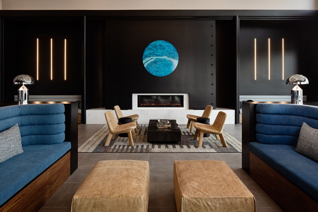 A living room with a blue couch, a wooden coffee table, and a large blue and white globe on the wall.