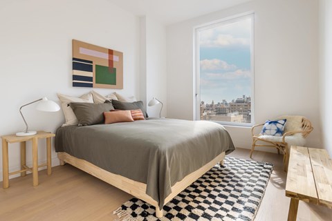A bedroom with a large bed and a view of the city.