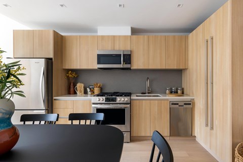 A modern kitchen with wooden cabinets and stainless steel appliances.