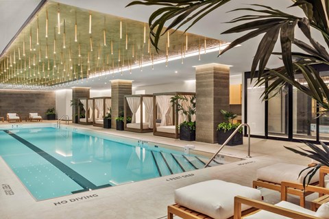 A large indoor swimming pool with a wooden lounge area.
