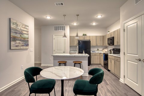 A kitchen with a table and chairs in the foreground.
