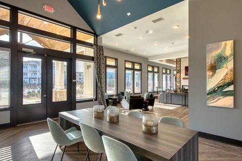 A dining room with a long table and chairs.