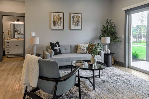 A grey couch with a white throw on it sits in a living room.