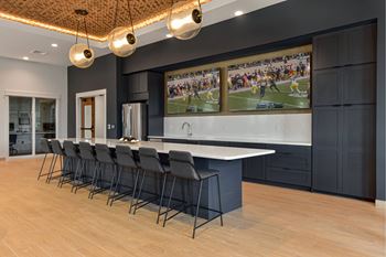 A modern kitchen with a long table and chairs.