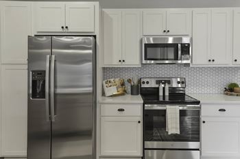 A kitchen with a stainless steel refrigerator and oven.