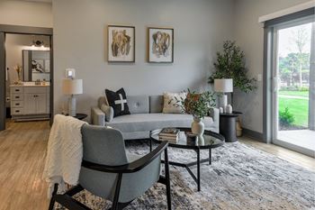 A grey couch with a white throw blanket on it sits in a living room.