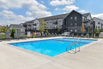 A swimming pool in front of apartment buildings.