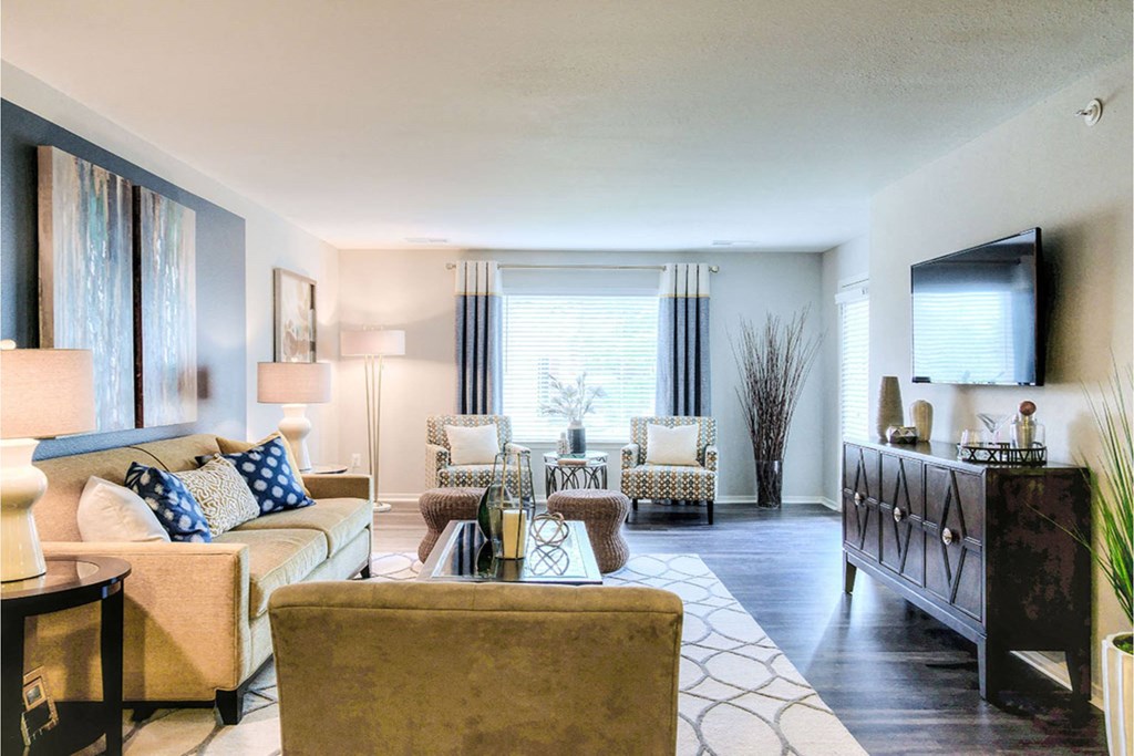 A living room with a sofa, armchairs, and a coffee table.