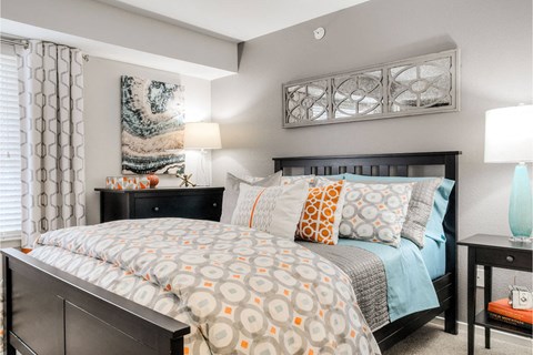 A bedroom with a large bed and a painting on the wall.