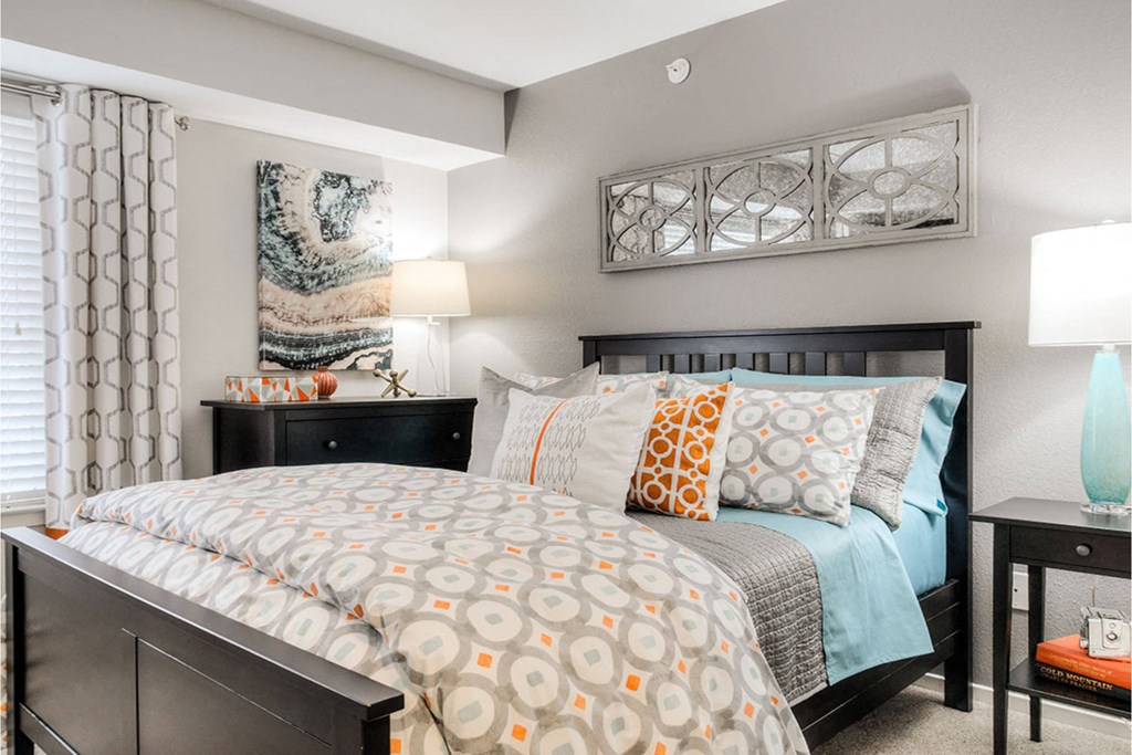 A bedroom with a large bed and a painting on the wall.