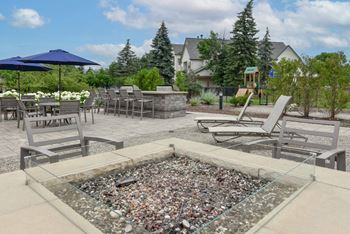 A glass table with a rock garden in the middle of a patio.
