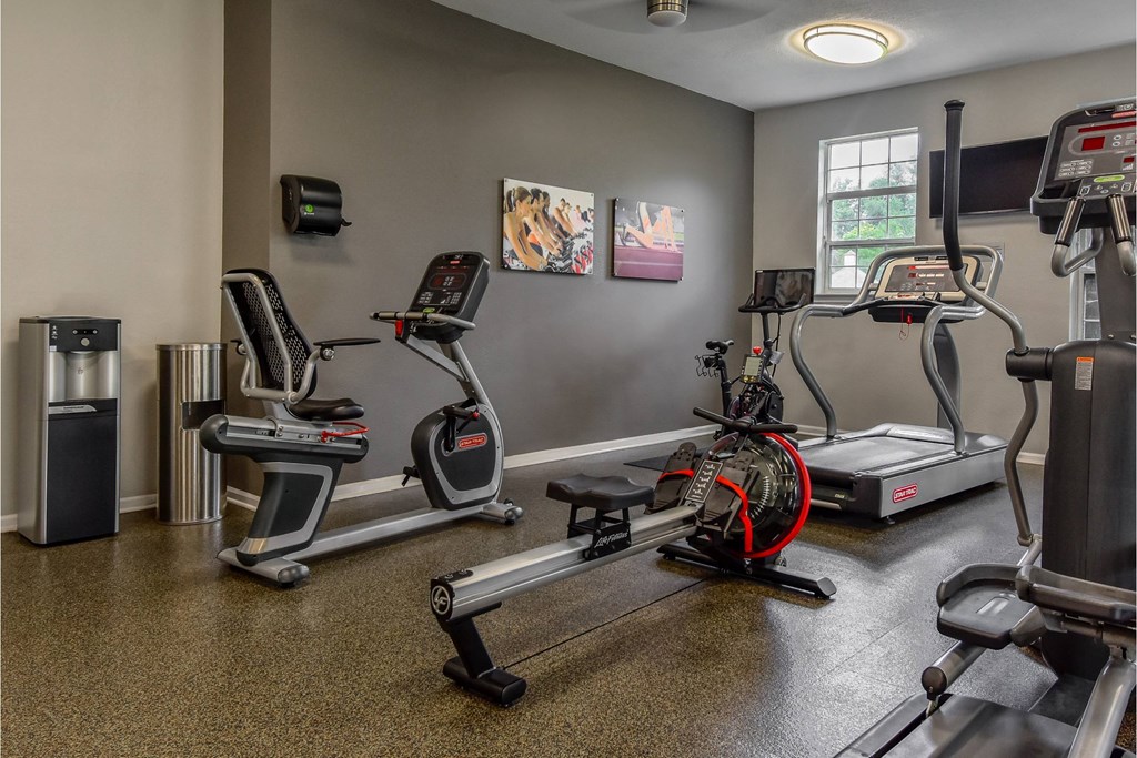 A gym with treadmills, elliptical machines, and other exercise equipment.