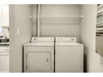 A white washing machine and dryer in a small laundry room.