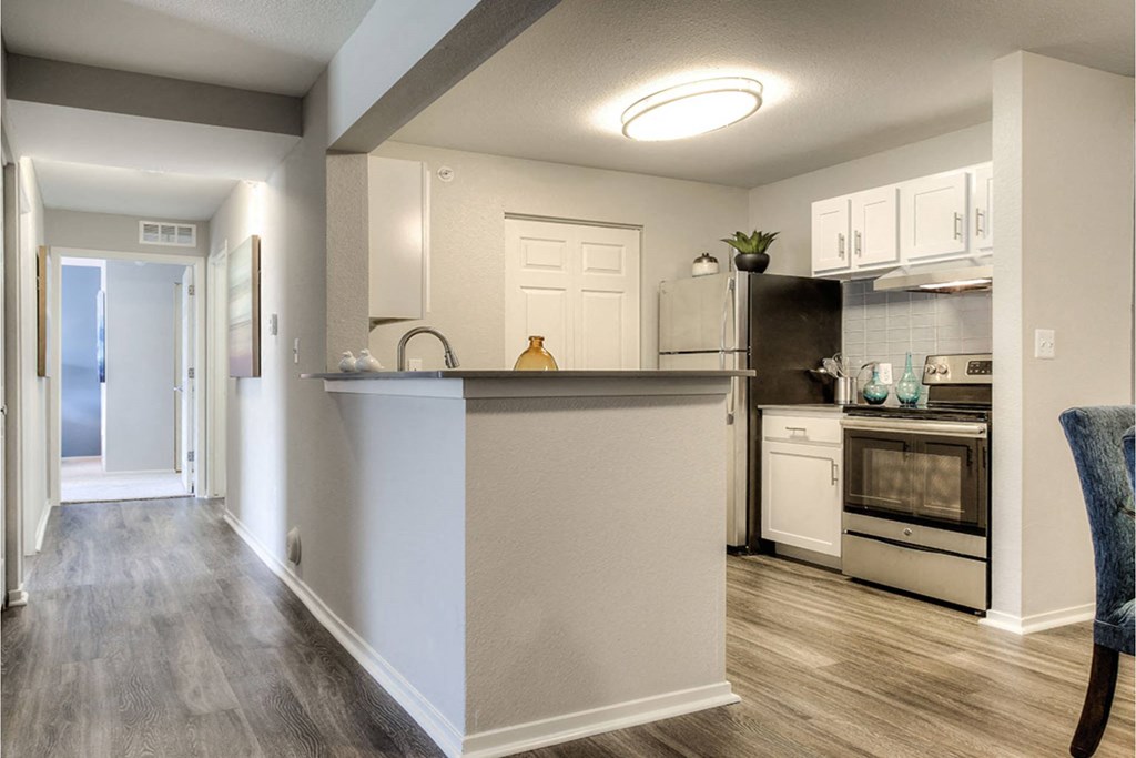 A kitchen with a white counter and a refrigerator.