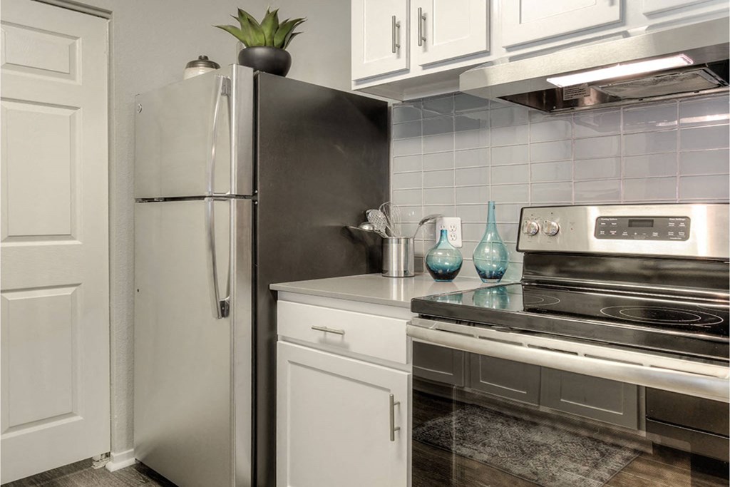 A kitchen with a stainless steel refrigerator and a stainless steel oven.