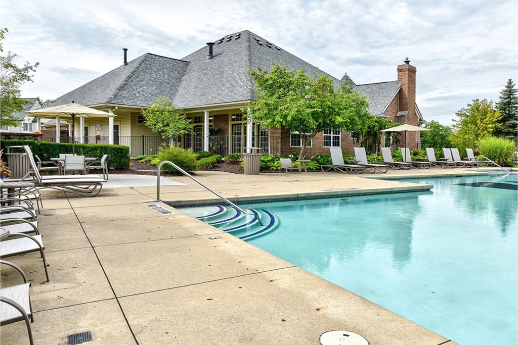 A pool with a house in the background.