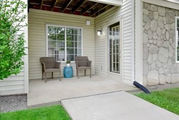 A patio with a table and chairs and a blue vase.