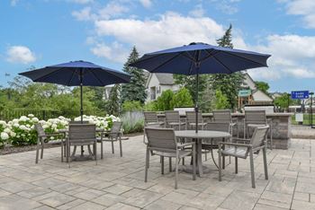 A patio with a table and chairs under umbrellas.