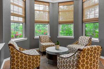 A living room with a table and three chairs.