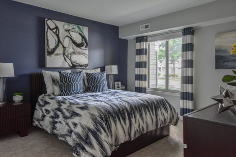 Bedroom with large windows and décor at The Villas at Northstar Ann Arbor apartments for rent.