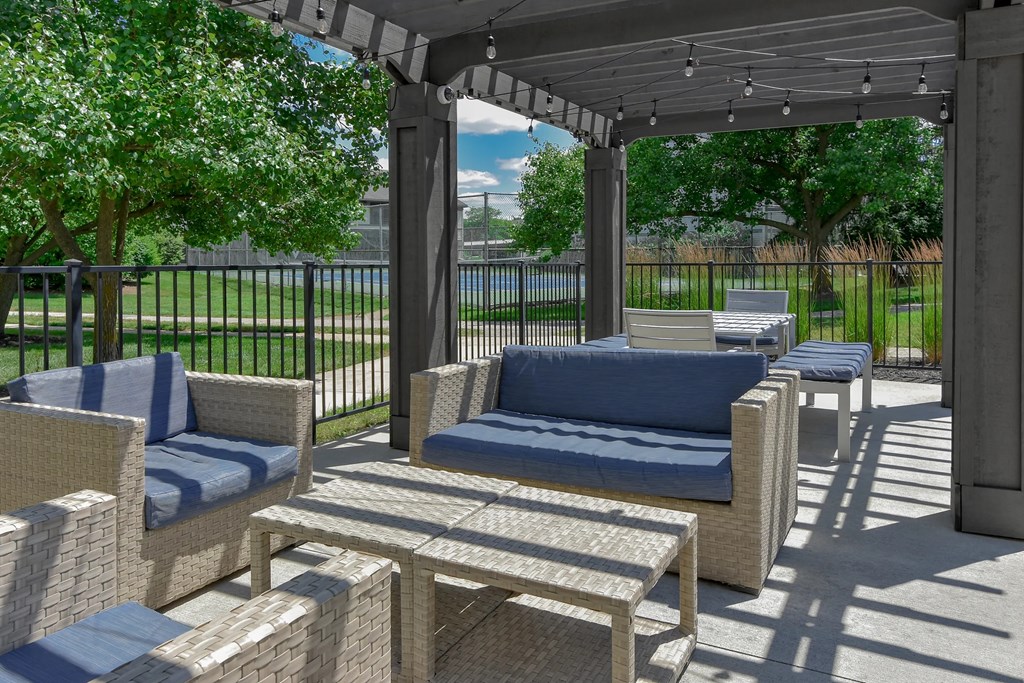A patio with a couch, chairs, and a table.