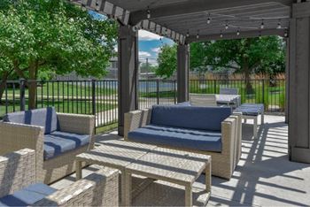 A patio with a couch, chairs, and a table.