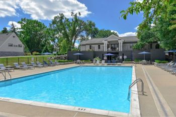 A large swimming pool surrounded by lounge chairs and umbrellas.